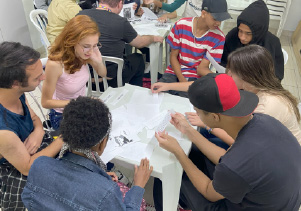 Foto de jovens conversando em volta da mesa na Oficina de Criatividade do CIEE