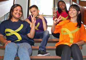 Quatro jovens sentados na escada da escola