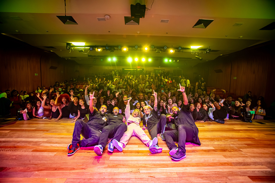 Cinco pessoas deitadas no palco do teatro