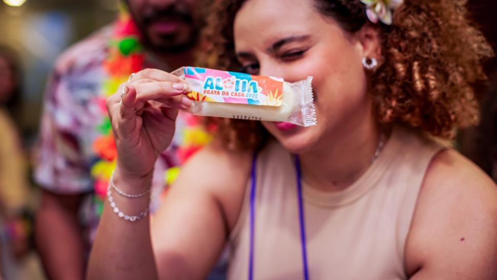 Mulher segura um picolé com os dizeres "Prata da Casa"