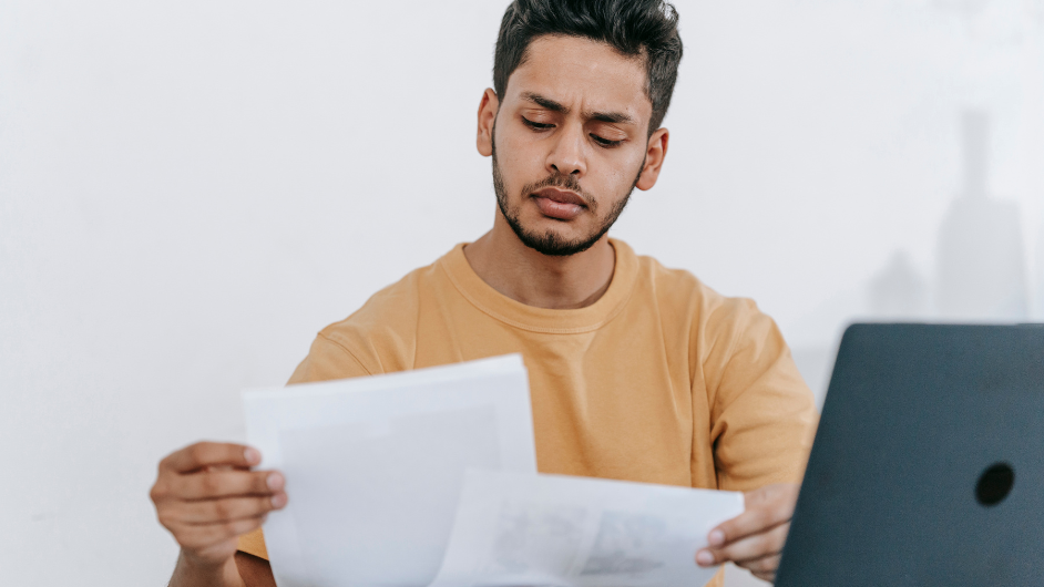 a imagem mostra um homem sério lendo um contrato