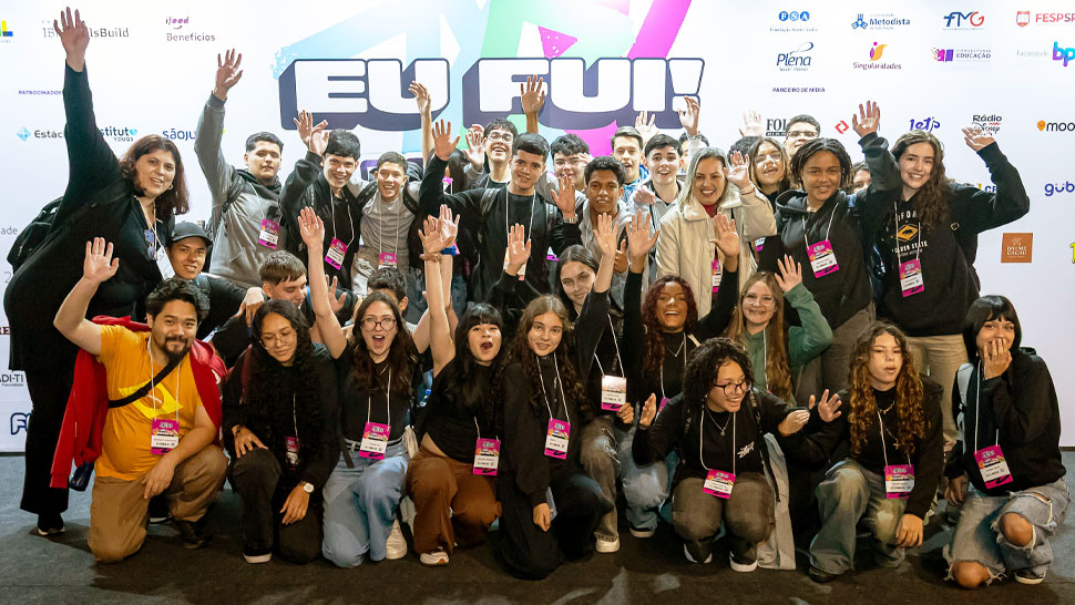 Jovens com os braços para cima comemorando