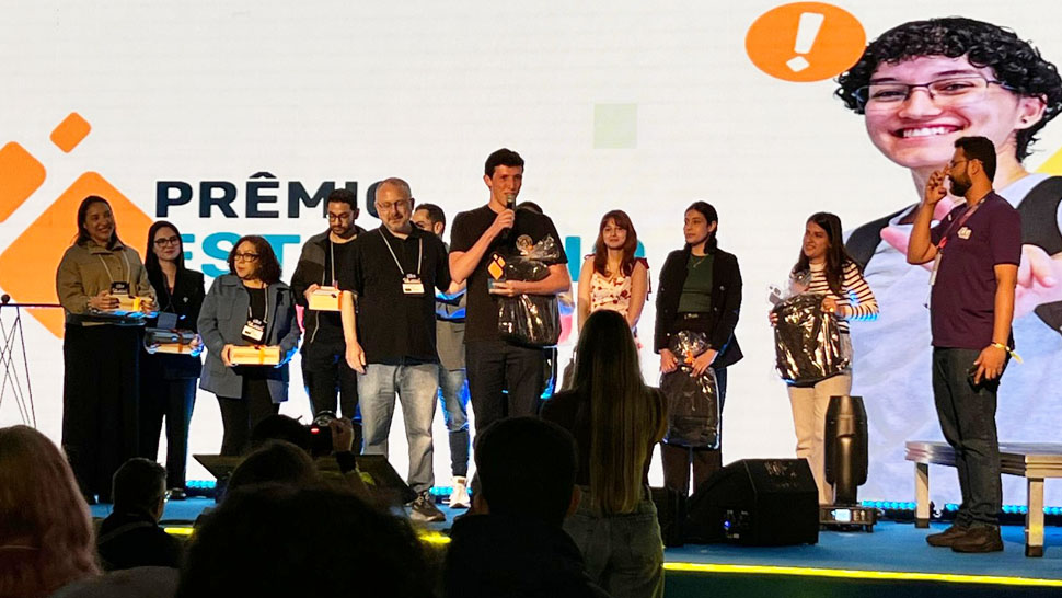 Jovem segurando uma mochila do CIEE, falando no palco do evento