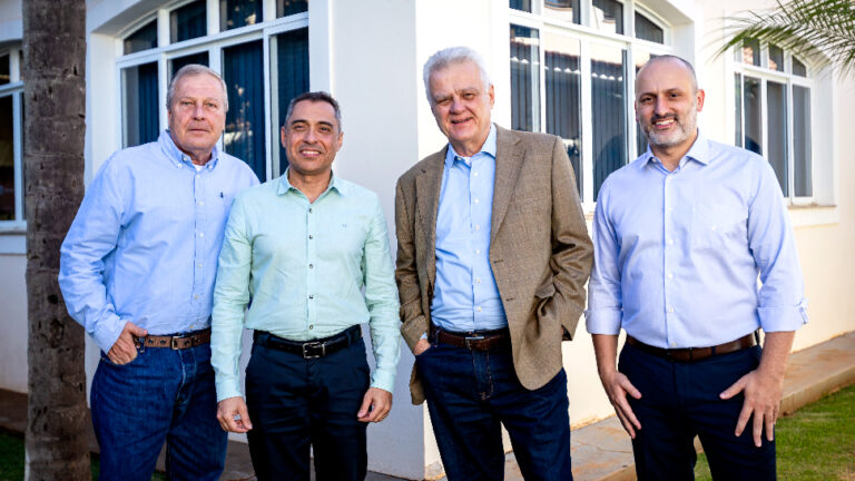 Quatro homens posando para a foto, em roupas sociais.