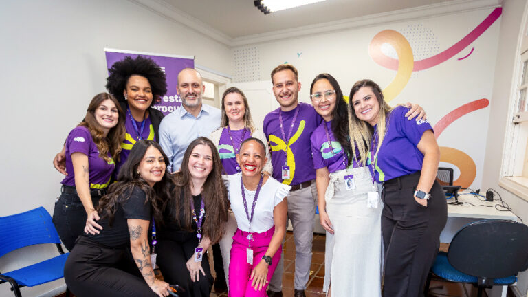 Equipe do CIEE de Piracicaba uniformizada de roxo posando para a foto.